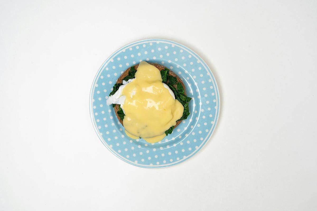 Une assiette bleue à pois avec un oeuf à la Florentine