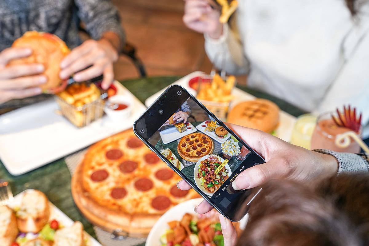 Une personne prend en photo son assiette