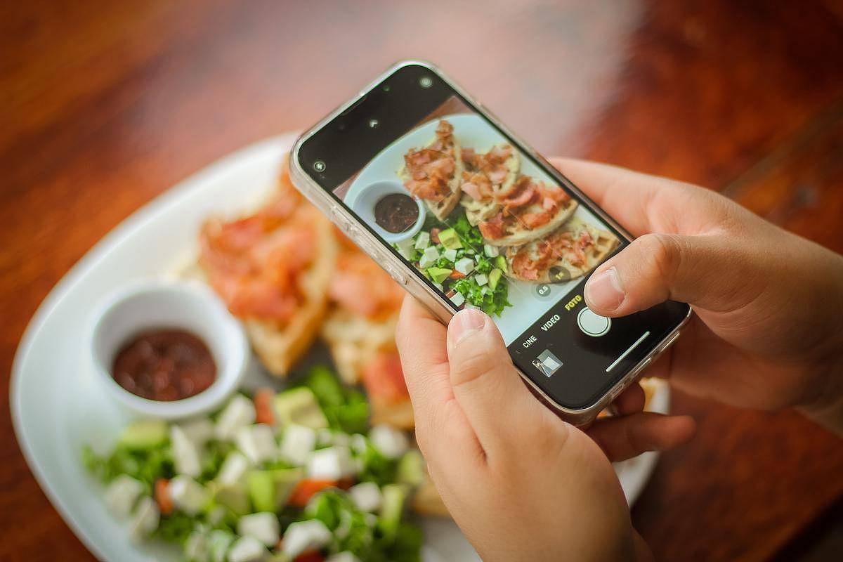 Une personne prend en photo son assiette