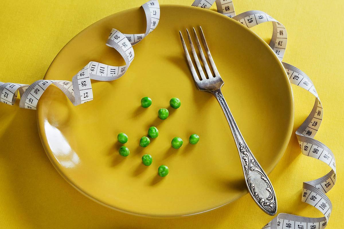 Une assiette jaune, quelques petits pois et un mètre de mesure