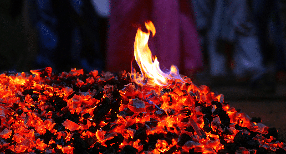 Un tas de braises incandescentes avec une petite flamme